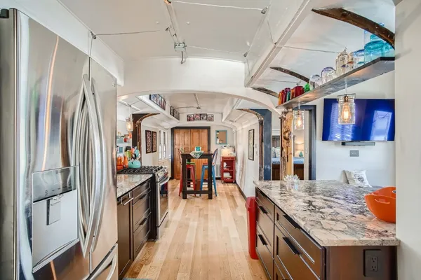 a kitchen with stainless steel appliances granite countertop lots of counter top space and wooden floor