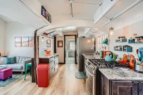 a kitchen with stainless steel appliances granite countertop a stove and a wooden floors