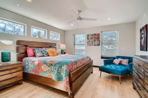 a bedroom with a bed a bookshelf and a window