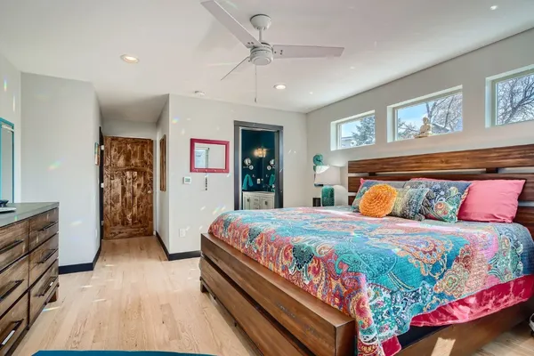 a bedroom with a large bed a flat tv screen and dresser