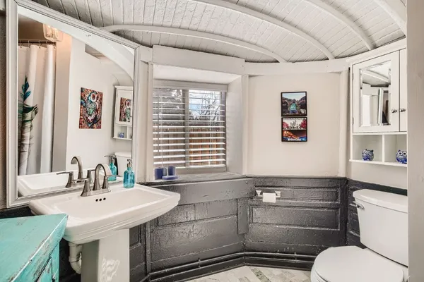 a bathroom with a sink a toilet and large mirror