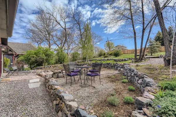 a view of a backyard with table and chairs and a fire pit