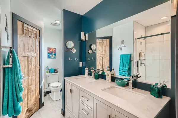 a bathroom with a granite countertop sink toilet and shower