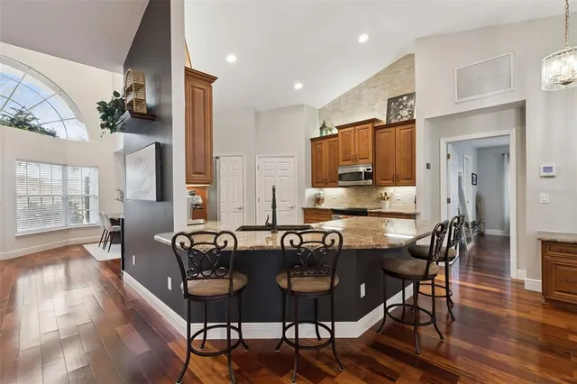 a kitchen with granite countertop stainless steel appliances a refrigerator and cabinets