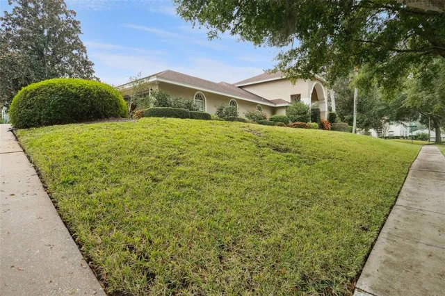an aerial view of a house with a yard green space and lake view