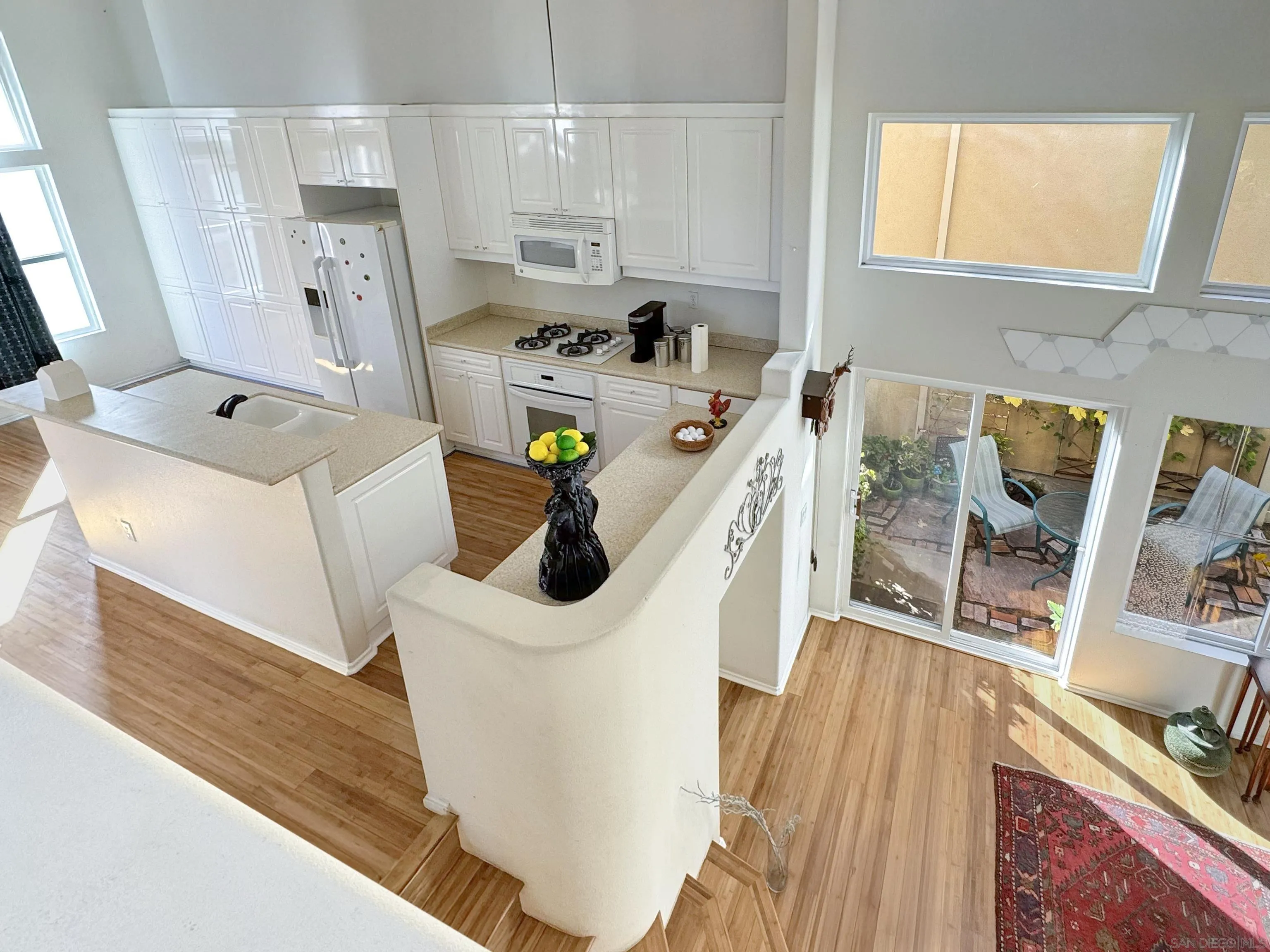 12654 Carmel Country Road, Unit 91 San Diego, CA 92130 - Photo 9 of 22 a kitchen with a sink a stove and wooden floor