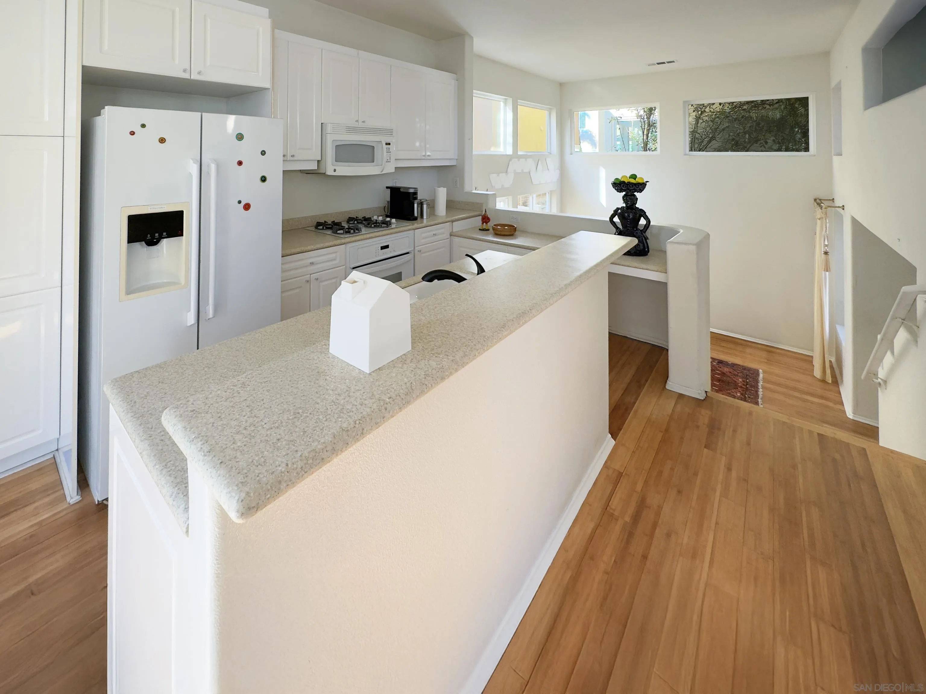 12654 Carmel Country Road, Unit 91 San Diego, CA 92130 - Photo 10 of 22 a kitchen with stainless steel appliances a refrigerator a stove a sink dishwasher and white cabinets with wooden floor