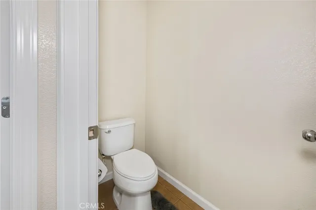 a white toilet sitting next to a white wall