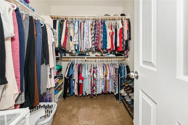 a view of walk in closet with clothes