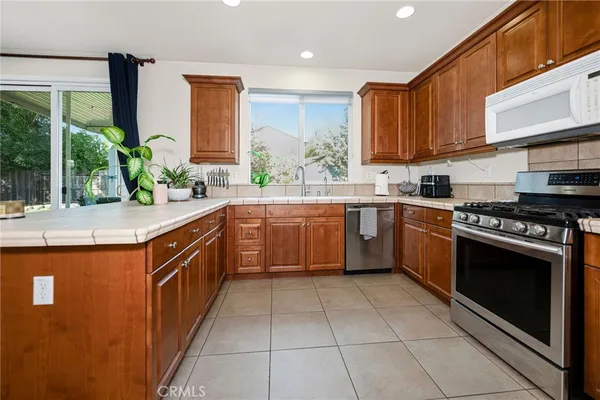 a kitchen with stainless steel appliances granite countertop a stove a sink and a microwave