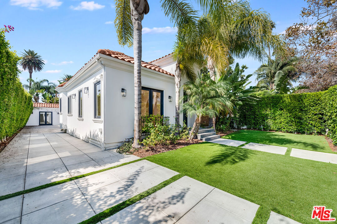 607 North La Jolla Avenue Los Angeles, CA 90048 - Photo 4 of 21 a view of a white house with a yard and potted plants