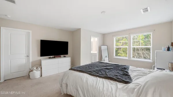 a bedroom with a bed and a flat screen tv