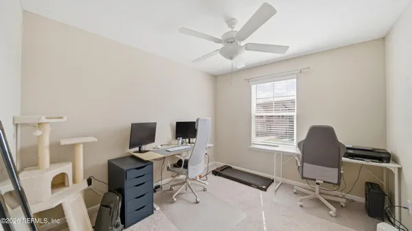 a view of a workspace with furniture and a window