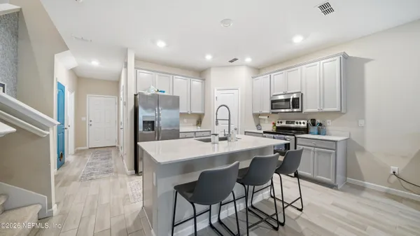 a kitchen with kitchen island a sink stove and refrigerator
