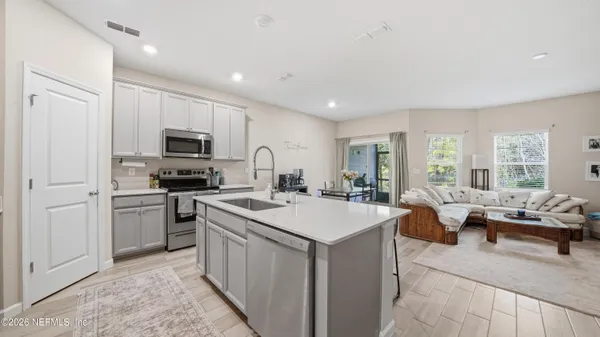 a kitchen with sink a refrigerator and furniture