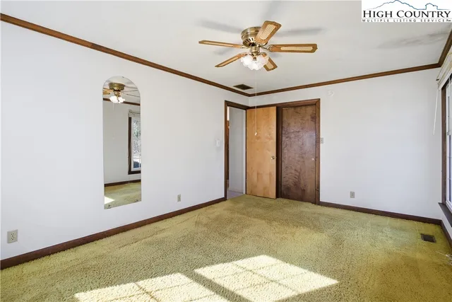 a view of an empty room with a chandelier fan