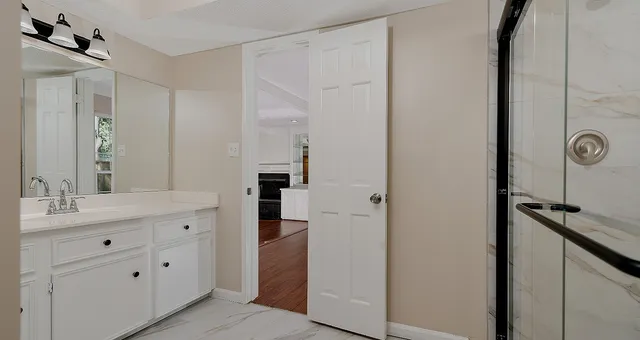 a spacious bathroom with a double vanity sink a mirror and shower