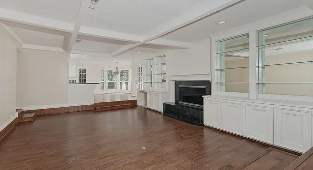 a view of empty room with wooden floor and fireplace