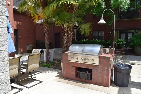 a view of backyard with barbeque grill and outdoor seating