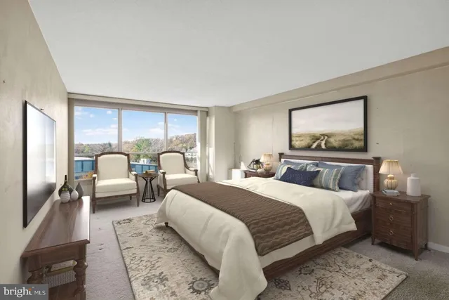 a bedroom with a bed couch and a large window