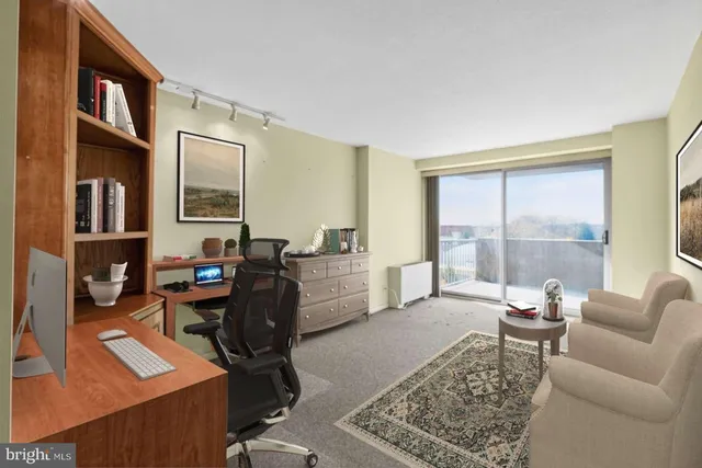 a living room with furniture a rug a lamp and a large window