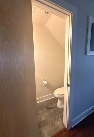 a bathroom with a granite countertop toilet and a shower
