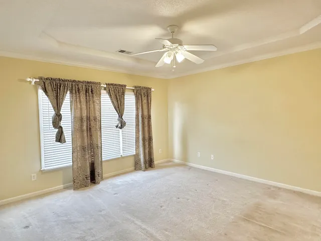 a view of an empty room with a chandelier fan
