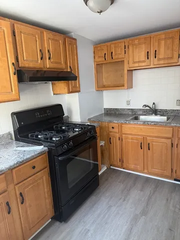 a kitchen with granite countertop a stove and a sink