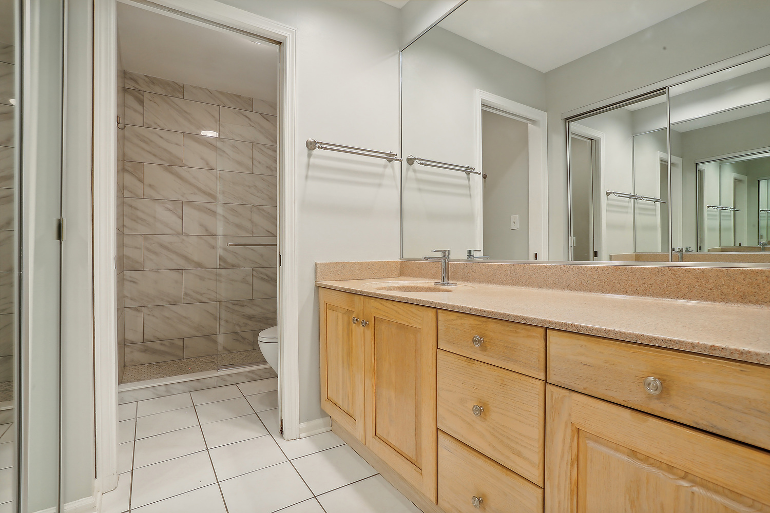 4010 Dundee Road Northbrook, IL 60062 - Photo 9 of 14 a bathroom with a shower a sink and a mirror