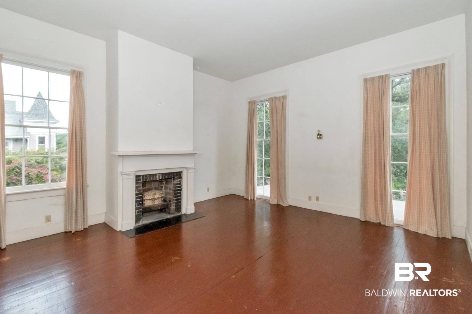 959 Dauphin Street Mobile, AL 36604 - Photo 29 of 43 Unfurnished living room featuring a fireplace and wood-type flooring