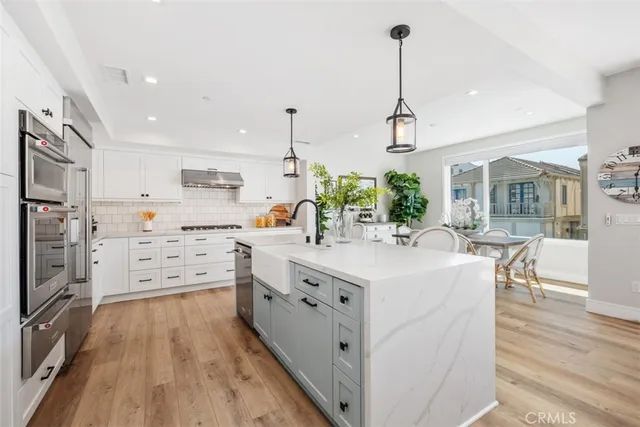 a kitchen with stainless steel appliances kitchen island granite countertop a stove a sink and a refrigerator