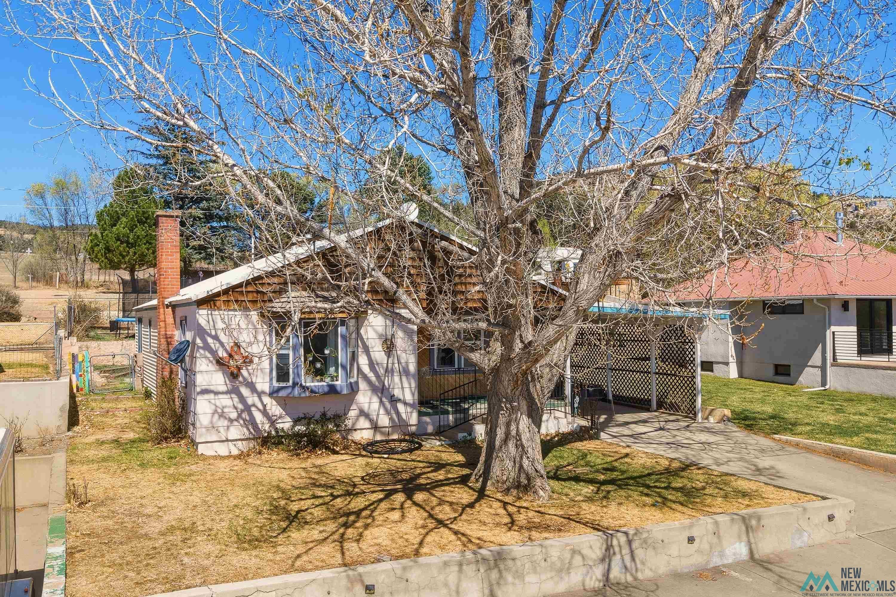 1432 South 5th Street Raton, NM 87740 - Photo 2 of 32 View of front of property featuring a chimney and a front lawn