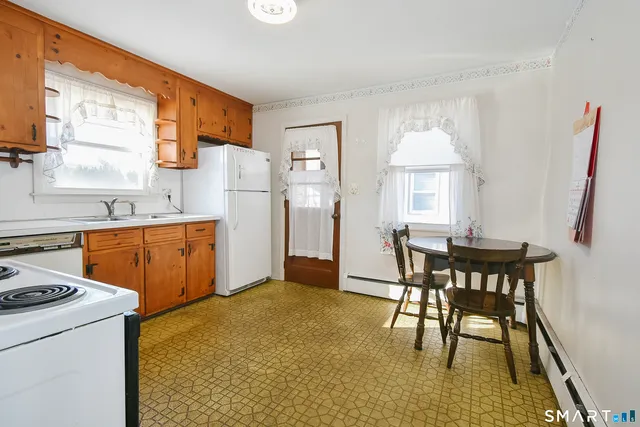 a kitchen with a table chairs and a refrigerator