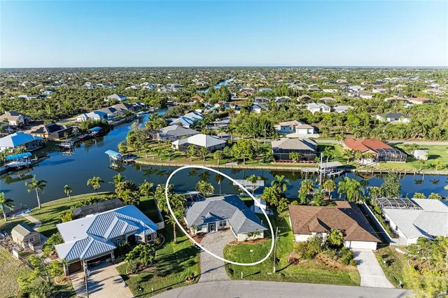 an aerial view of a house with a swimming pool lake view and mountain view