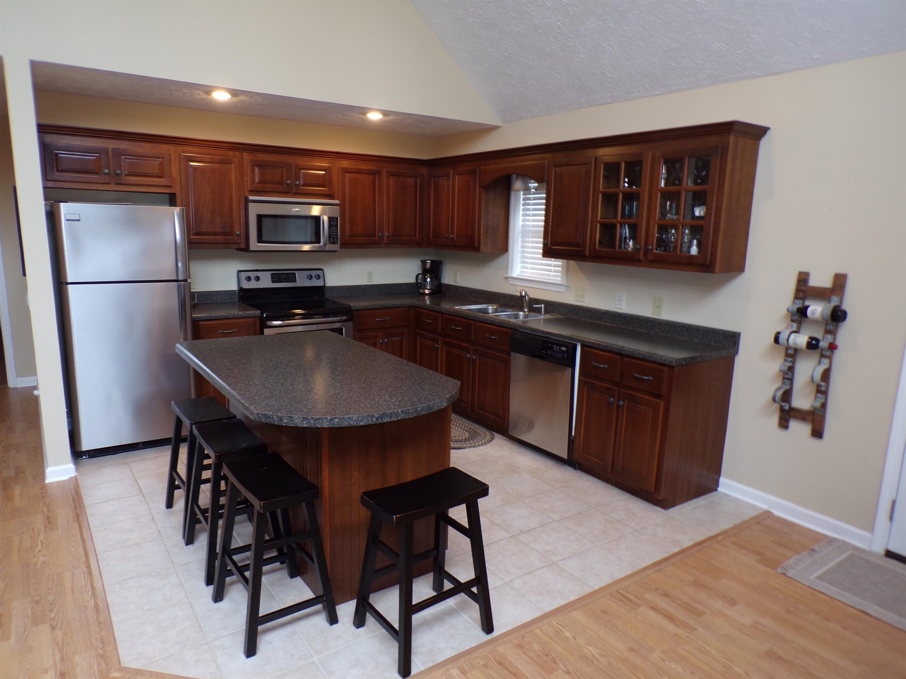 265 Missabbey Lane Counce, TN 38326 - Photo 7 of 21 a kitchen with stainless steel appliances granite countertop a table chairs refrigerator and microwave