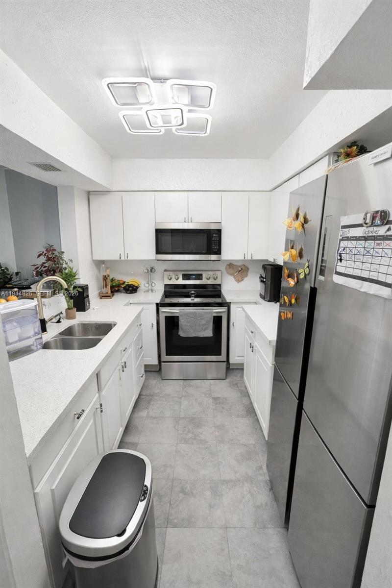 8460 Southwest 154th Cir Court, Unit 121 Miami, FL 33193 - Photo 4 of 9 a kitchen with a sink appliances and cabinets