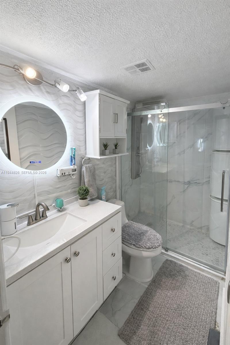 8460 Southwest 154th Cir Court, Unit 121 Miami, FL 33193 - Photo 5 of 9 a bathroom with a double vanity sink mirror and shower