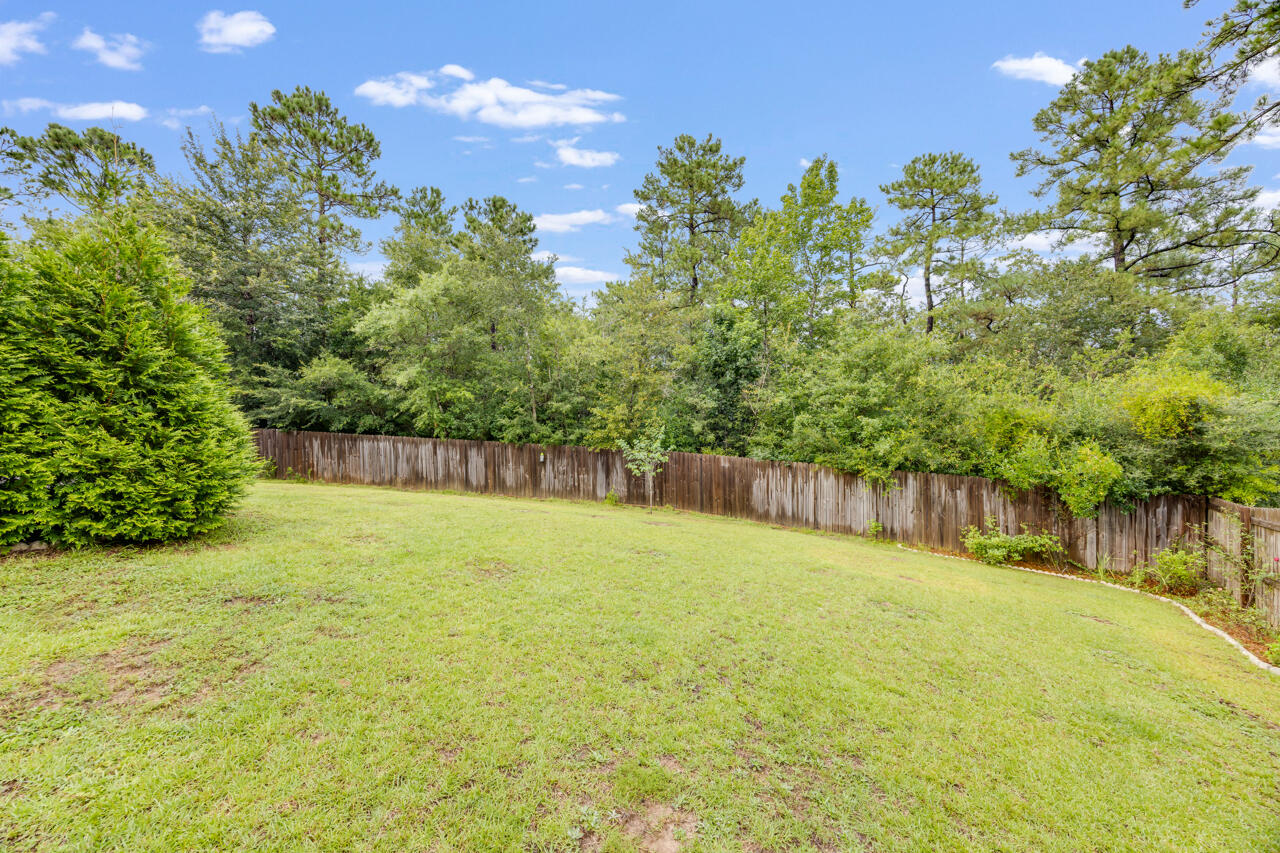 4648 Plover Drive Crestview, FL 32539 - Photo 45 of 71 a backyard of a house with lots of green space and tree