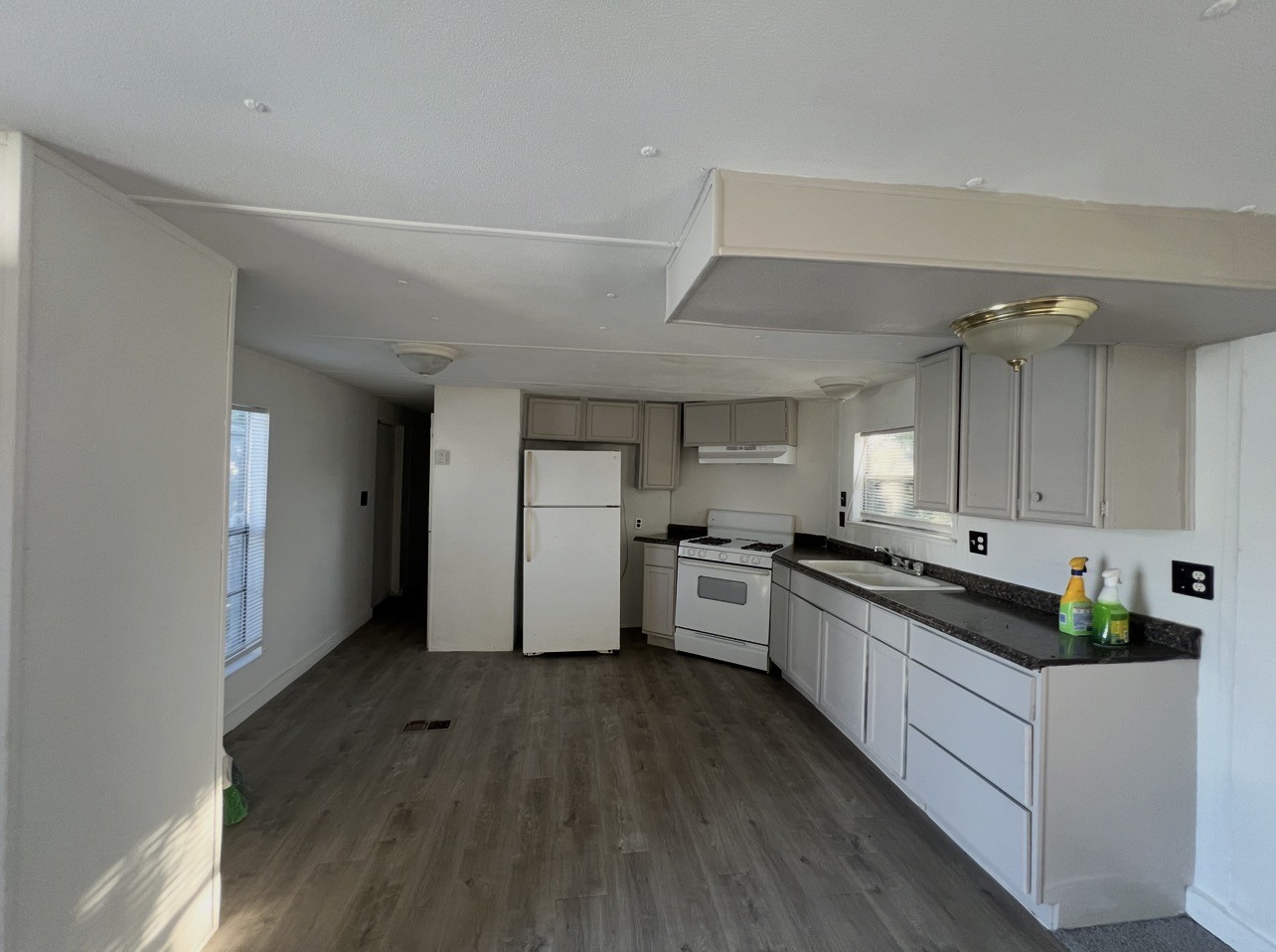 1511-1 Jones Street, Unit 1 Rosenberg, TX 77471 - Photo 6 of 13 a kitchen with granite countertop a stove top oven a sink dishwasher and a refrigerator with wooden floor