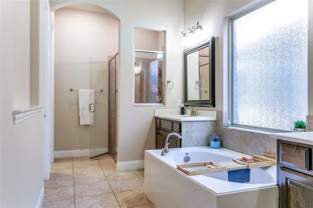 a bathroom with a tub sink and mirror