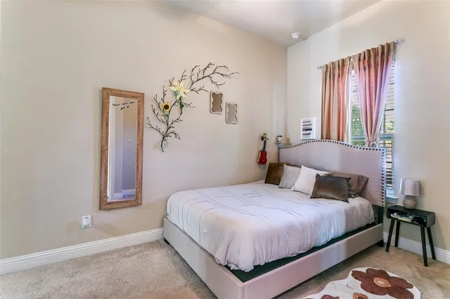 a bedroom with a bed lamp and a window