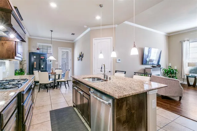 a dining hall with stainless steel appliances kitchen island a table and chairs in it