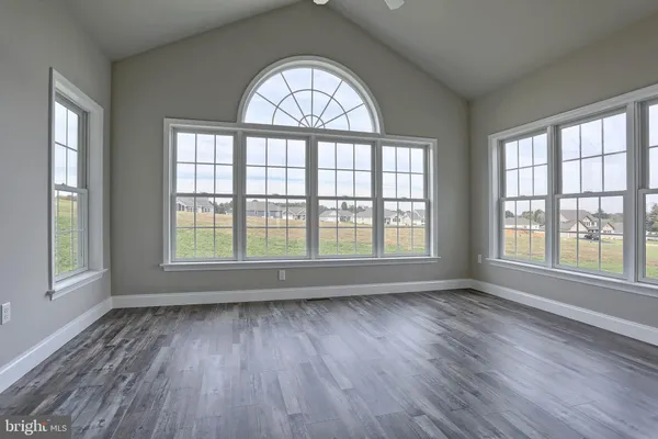 an empty room with wooden floor windows and a wooden floor