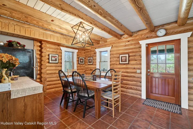 a spacious bedroom with a large bed a chandelier and windows