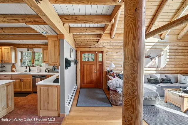 a kitchen with stainless steel appliances granite countertop a dining table chairs refrigerator and wooden cabinets