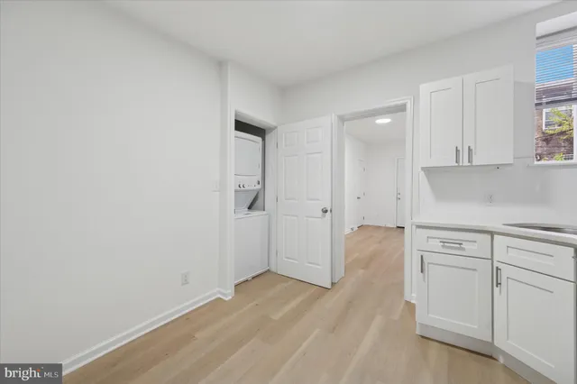 a view of a kitchen with white cabinets and wooden floor