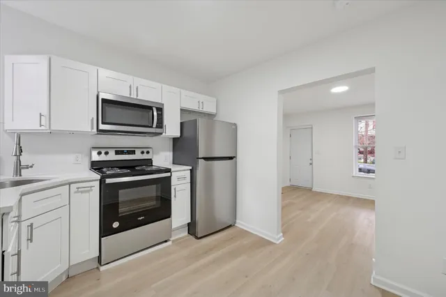 a kitchen with granite countertop a refrigerator and a stove top oven