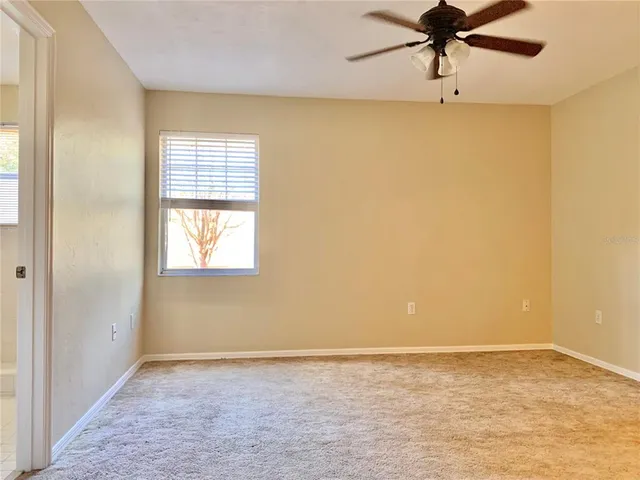 an empty room with a window and a fan