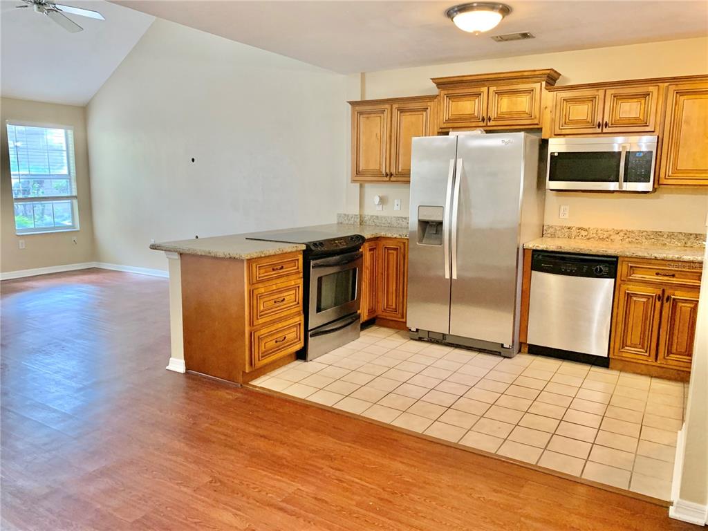 5268 Southwest 97 Way Gainesville, FL 32608 - Photo 3 of 33 a kitchen with stainless steel appliances granite countertop a refrigerator a stove a sink and a microwave