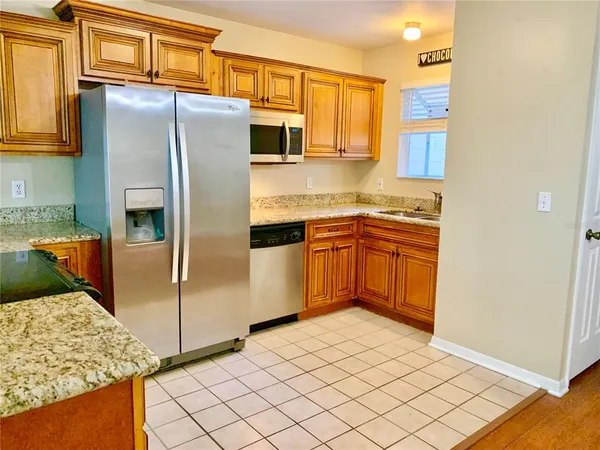 a kitchen with stainless steel appliances granite countertop a refrigerator and a stove top oven